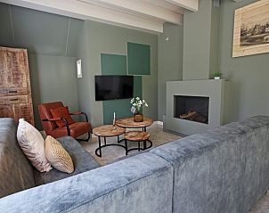 Gezellige woonkamer van Vakantiewoning Molenbosch in Doorn, Utrechtse Heuvelrug, met comfortabele zithoek en moderne open haard.