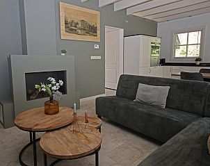 Gezellige woonkamer in Vakantiewoning Molenbosch, Doorn, Utrechtse Heuvelrug. Moderne inrichting met open haard en comfortabele zitruimte.