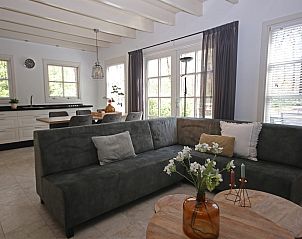 Gezellige binnenruimte van Vakantiewoning Molenbosch in Doorn, Utrechtse Heuvelrug, met comfortabele zithoek en veel natuurlijk licht.