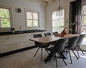Gezellige eetruimte in Vakantiewoning Molenbosch, Doorn, Utrechtse Heuvelrug, met uitzicht op groene tuin en moderne inrichting.
