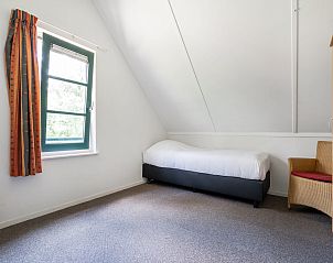 Slaapkamer in Vakantiewoning Beukenrode, Doorn, Utrechtse Heuvelrug met een comfortabel bed en uitzicht op de groene omgeving.
