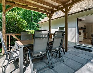 Genieen Sie die Ruhe und den Frieden auf der Terrasse der Vakantiewoning Drieburg in Doorn, Utrechtse Heuvelrug, mit Blick auf die grne Umgebung.