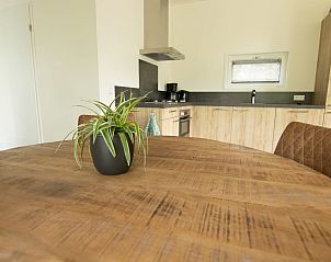 Stijlvolle eetruimte in Bungalow Zuylestein, Doorn, met houten tafel en uitzicht op de omgeving.