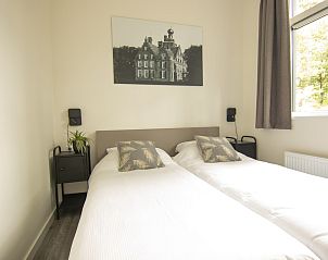 Slaapkamer met tweepersoonsbed in Bungalow Zuylestein, Doorn, rustiek en comfortabel.