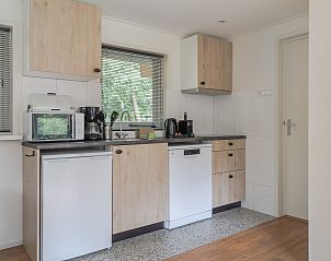 Eethoek in Bungalow Ruiterberg, Doorn met uitzicht op de groene omgeving van de Utrechtse Heuvelrug.