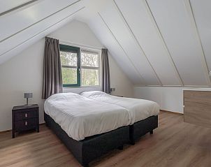 Eethoek en woonkamer van Vakantiewoning Heidestein in Doorn met uitzicht op de tuin.