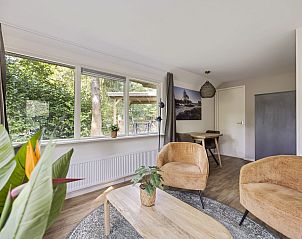 Lichte woonkamer van Bungalow Anderstein, Doorn, Utrechtse Heuvelrug met uitzicht op de natuur.