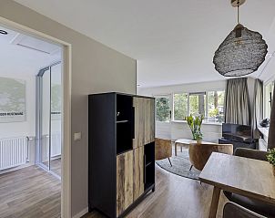 Open woonruimte in Bungalow Anderstein, Doorn, Utrechtse Heuvelrug met houten meubels en veel licht.