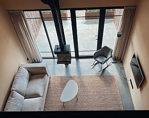 Luchtig interieur van Vakantiehuisje in Rhenen, Utrechtse Heuvelrug, met grote ramen en comfortabele zithoek.