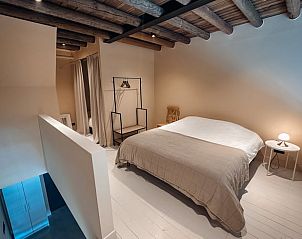 Slaapkamer in Vakantiehuisje in Rhenen, Utrechtse Heuvelrug, met houten balken en rustige ambiance.
