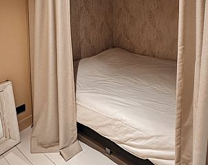 Knusse slaapnis in Vakantiehuisje in Rhenen, Utrechtse Heuvelrug, met gordijnen voor extra privacy.