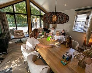 Gezellige familietijd in de woonkamer van Vakantiehuis De Thijmse Berg, Rhenen, Utrechtse Heuvelrug.