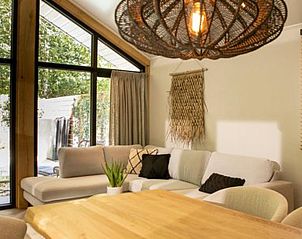 Stijlvolle woonkamer met designlamp in Vakantiehuis De Thijmse Berg, Rhenen, Utrechtse Heuvelrug.