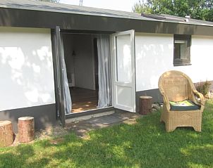 Gezellige entree van Vakantiehuis in Rhenen, Utrechtse Heuvelrug met uitnodigende stoel.