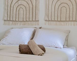 Detail van het bed in Huisje in Rhenen, Utrechtse Heuvelrug, met zachte kussens en stijlvolle decoratie.