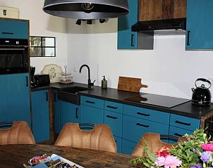 Volledig uitgeruste keuken in Vakantiehuisje in Achterveld, Utrechtse Heuvelrug, met blauwe kasten en moderne apparatuur.