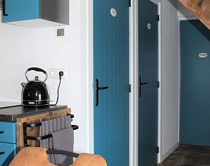 Keukendeur en gang in Vakantiehuisje in Achterveld, Utrechtse Heuvelrug, met blauwe accenten.