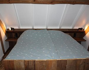 Knusse slaapkamer met houten details in Vakantiehuisje in Achterveld, Utrechtse Heuvelrug, Utrecht.