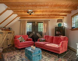 Comfortabele zithoek in vakantiehuisje in Maarsbergen met rode banken, Utrechtse Heuvelrug.