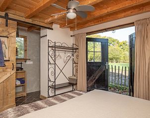 Slaapkamer in vakantiehuisje in Maarsbergen met uitzicht op tuin, Utrechtse Heuvelrug.