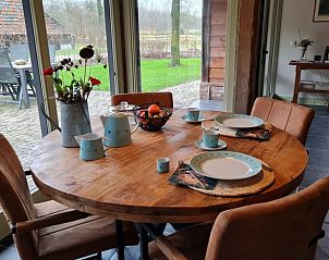 Eettafel in Vakantiehuisje in Maarsbergen met uitzicht op de tuin, ideaal voor gezellige maaltijden op de Utrechtse Heuvelrug.