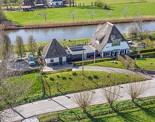Luftaufnahme eines Ferienhauses in Hekendorp, Utrecht, mit Reetdach und Blick auf einen ruhigen Fluss und eine grne Umgebung.