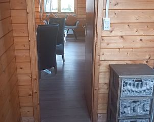 View through from bedroom to living room in Holiday Home in Wissenkerke, North Beveland, with warm wooden walls.