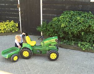 Child plays with toy tractor at Holiday Home in Wissenkerke, North Beveland, for outdoor fun.