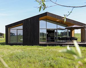 Modern cottage facade of House in Wissenkerke, Zeeland in green surroundings.