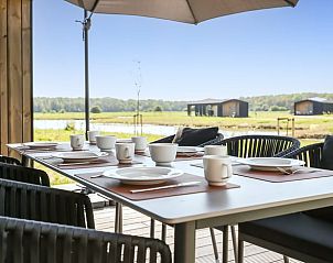 Terrace with set table at cottage in Wissenkerke, ideal for outdoor dining.