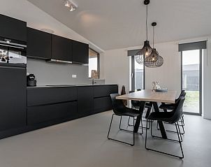 Dining room with modern lighting in Cottage in Wissenkerke, perfect for cozy evenings.