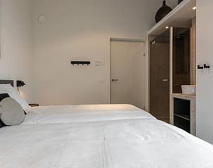 Modern bedroom in cottage in Wissenkerke with attached bathroom in Zeeland.