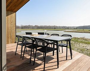 Terrace overlooking water at Huisje in Wissenkerke, a vacation home in Wissenkerke, North Beveland, Zeeland.