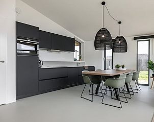 Modern kitchen of cottage in Wissenkerke with dining area, ideal for vacations in North Beveland, Zeeland.