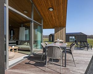 Zonnig terras in Vakantiehuisje in Wissenkerke, Noord-Beveland, Zeeland met uitzicht op de velden.