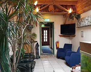 Gemtlicher Innenraum des Inn d'n Eenhoorn in Colijnsplaat, Nord-Beveland, mit bequemen Sitzgelegenheiten und grnen Akzenten.