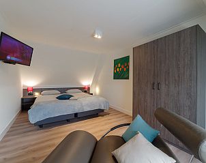 Gemtliches Schlafzimmer im Ferienhaus Ganuenta, Colijnsplaat, Noord-Beveland mit Fernseher und Kunst an der Wand.