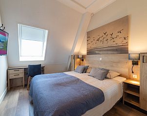 Gezellige slaapkamer in Appartement Ganuenta, Colijnsplaat, Noord-Beveland, met comfortabel tweepersoonsbed en rustieke inrichting.