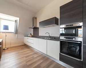 Strakke keuken in Appartement Ganuenta, Colijnsplaat, Noord-Beveland, met moderne apparatuur en veel werkruimte.