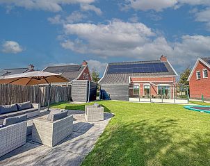 Ruim terras bij Dune Design 39 vakantiehuis in Colijnsplaat, Noord-Beveland, met comfortabele zithoek en groene tuin in zonnige omgeving.