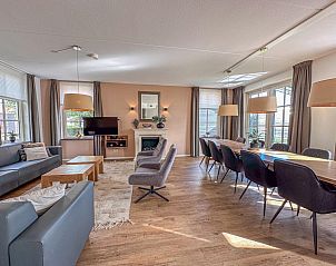 Ruime woonkamer van vakantiehuis Dune Design 39 in Colijnsplaat, Noord-Beveland, Zeeland met comfortabele zithoek en grote eettafel.