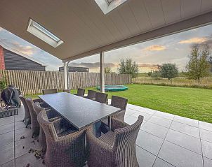 Overdekt terras van Coast Comfort in Colijnsplaat biedt een ontspannen eetruimte met uitzicht op de tuin, Noord-Beveland, Zeeland.