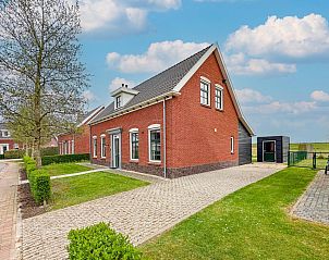 Vooraanzicht van Sea Sun Relax 37 in Colijnsplaat, charmant vakantiehuis met rode bakstenen en groene omgeving.