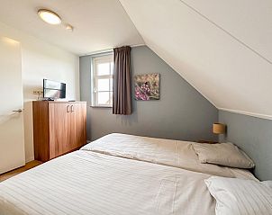 Slaapkamer met televisie in Sea Sun Relax 37 in Colijnsplaat, vakantiehuis met comfortabele bedden.