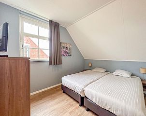 Gezellige slaapkamer in Sea Sun Relax 37 in Colijnsplaat, vakantiehuis met warme verlichting en houten meubels.