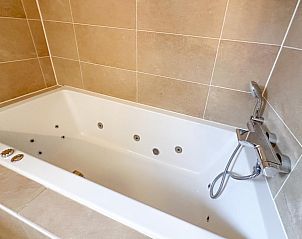 Jacuzzi in badkamer van Sea Sun Relax 37 in Colijnsplaat, vakantiehuis met luxe wellness faciliteiten.