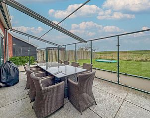 Overdekt terras van Sea Sun Relax 37 in Colijnsplaat, vakantiehuis met grote eettafel en uitzicht op de natuur.