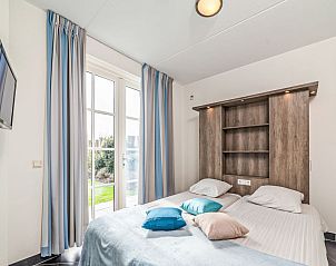 Sfeervolle slaapkamer met tuinzicht in Vakantiehuis Ganuenta, Colijnsplaat, Noord-Beveland, Zeeland.