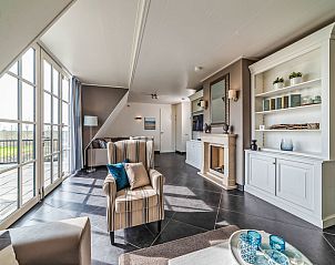 Lichte woonkamer met balkon in Vakantiehuis Ganuenta, Colijnsplaat, Noord-Beveland, Zeeland.