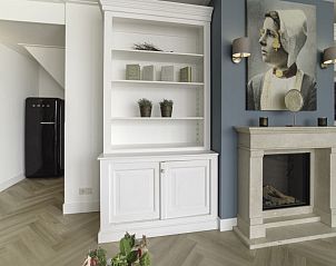 Interieur met open haard en kunst in Vakantiehuis Ganuenta, Colijnsplaat, Noord-Beveland, Zeeland.